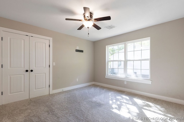 unfurnished bedroom featuring light carpet, a closet, and ceiling fan