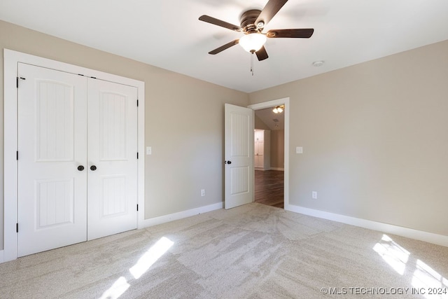 unfurnished bedroom with a closet, ceiling fan, and light colored carpet