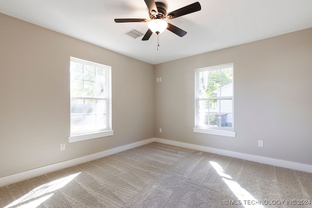 carpeted empty room featuring ceiling fan and a healthy amount of sunlight