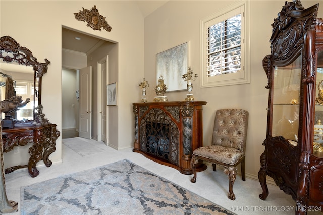 living area featuring crown molding, vaulted ceiling, and light carpet