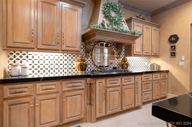 kitchen featuring custom exhaust hood, ornamental molding, light tile patterned floors, stainless steel gas stovetop, and tasteful backsplash