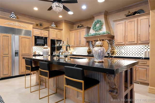 kitchen featuring crown molding, a center island, built in appliances, and ceiling fan