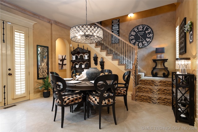 dining area with crown molding and a notable chandelier