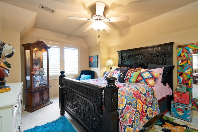 bedroom with vaulted ceiling, light colored carpet, and ceiling fan