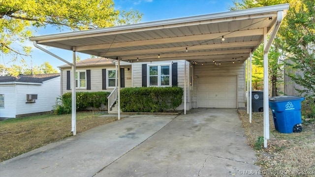 6944 E 7th St, Tulsa, OK 74112 - view of front facade with a carport, driveway, and a garage