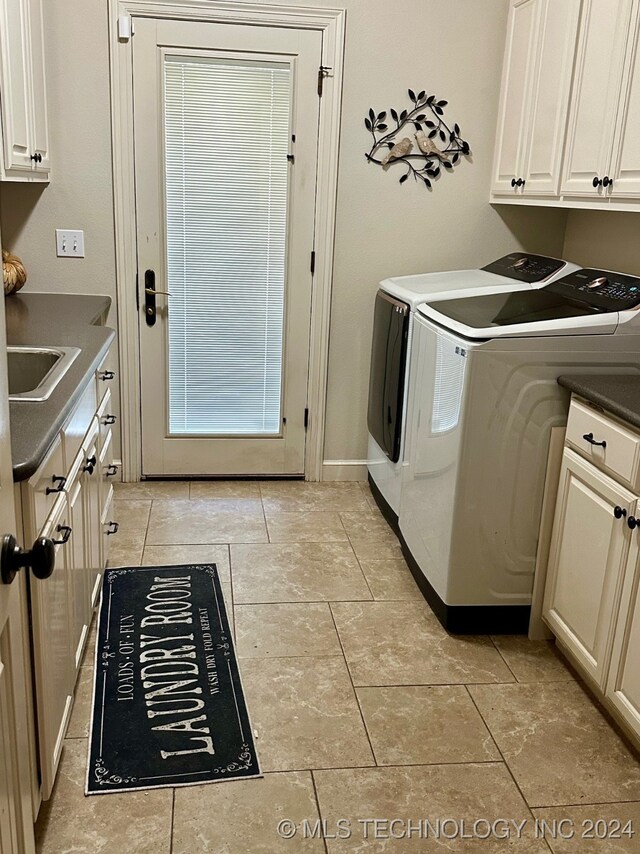 laundry area with a sink, washing machine and dryer, cabinet space, and baseboards