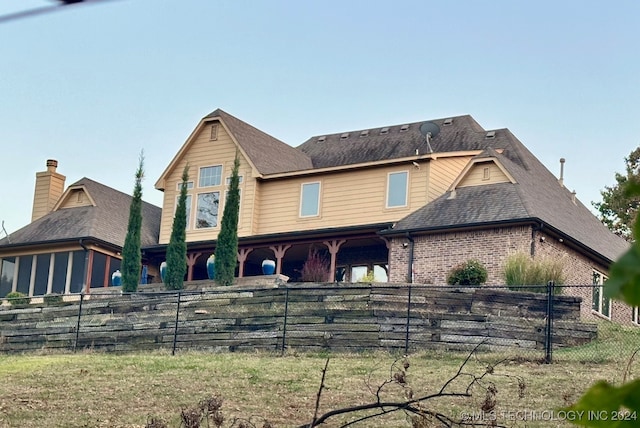 view of front facade featuring brick siding and fence