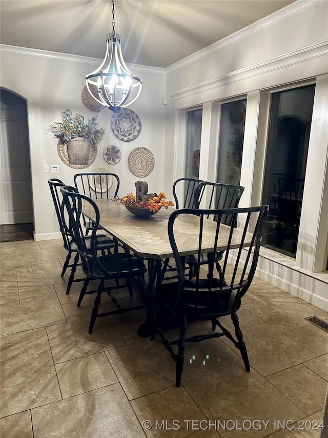 dining room with baseboards, visible vents, and crown molding