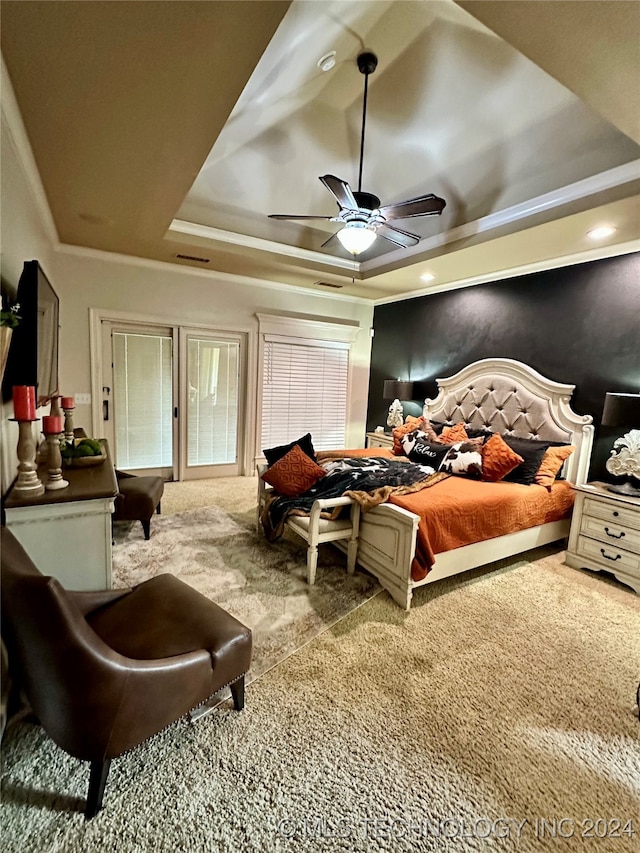 bedroom featuring ceiling fan, carpet floors, a tray ceiling, and visible vents