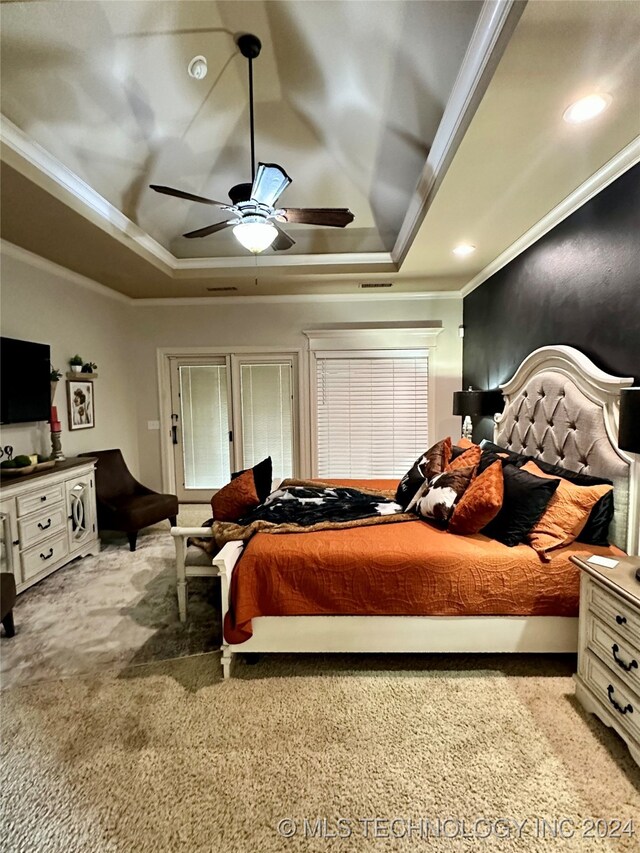 bedroom with ceiling fan, ornamental molding, a raised ceiling, and carpet flooring