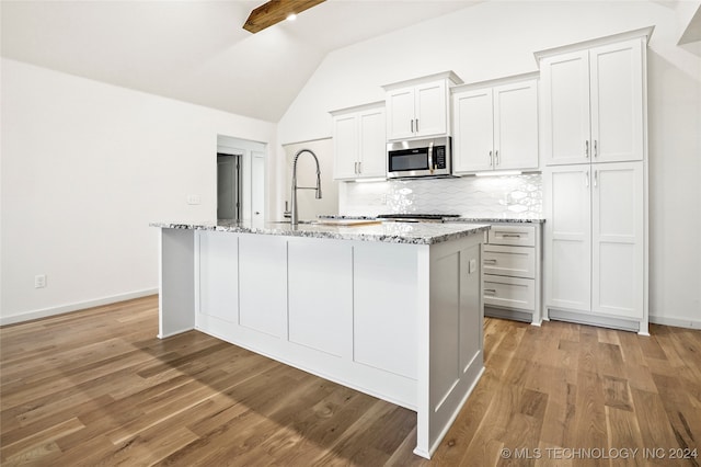 kitchen featuring a center island with sink, light hardwood / wood-style flooring, stainless steel appliances, and white cabinets