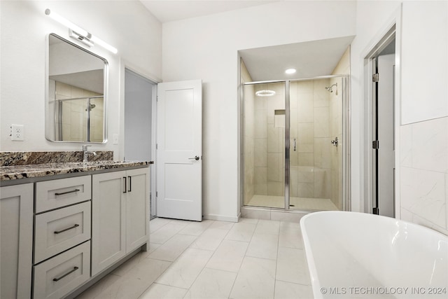 bathroom with vanity and shower with separate bathtub