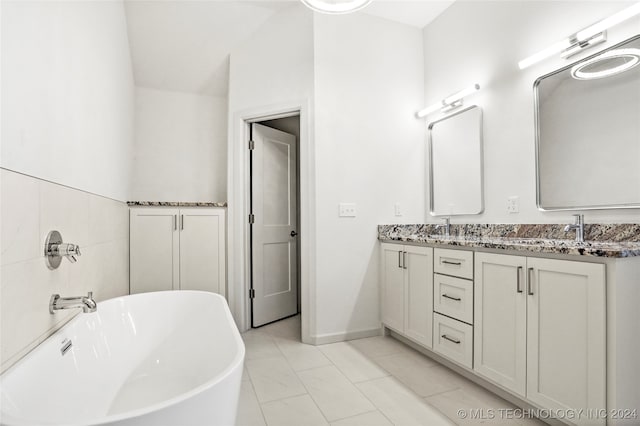 bathroom with vanity, a bathtub, and vaulted ceiling