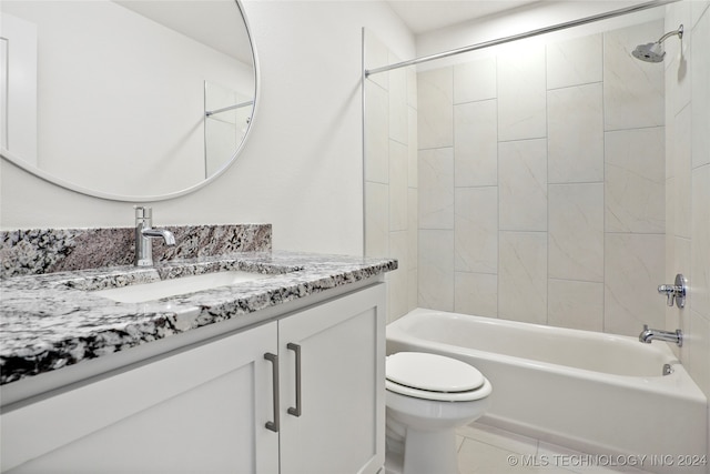 full bathroom featuring tiled shower / bath, vanity, toilet, and tile patterned floors