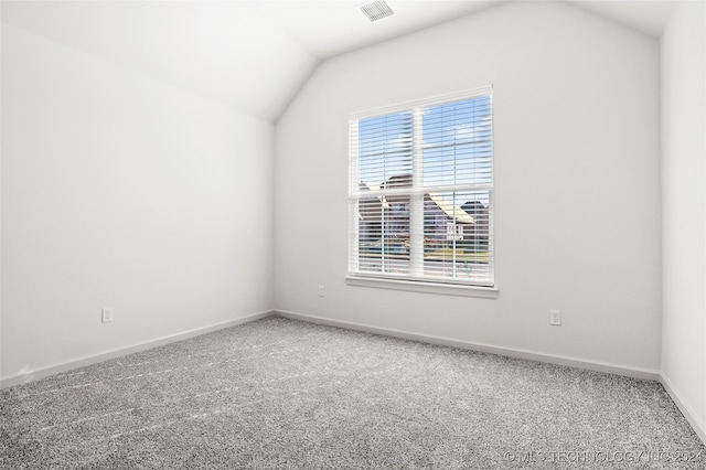 spare room with lofted ceiling and carpet flooring