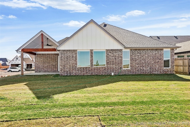 rear view of property featuring a lawn