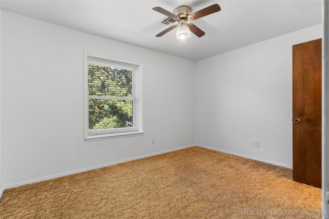 carpeted spare room featuring ceiling fan and baseboards