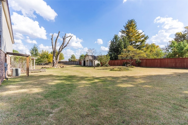 view of yard featuring an outbuilding, a fenced backyard, and a shed