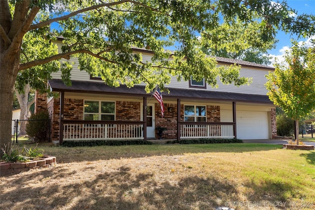 view of front of property with covered porch, an attached garage, and a front lawn