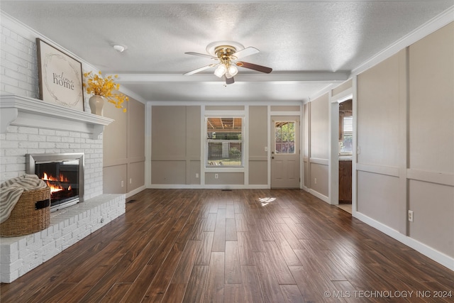 unfurnished living room featuring a textured ceiling, a brick fireplace, wood finished floors, and a decorative wall