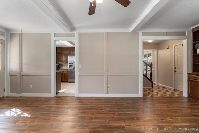 empty room featuring crown molding, ceiling fan, wood finished floors, and a decorative wall