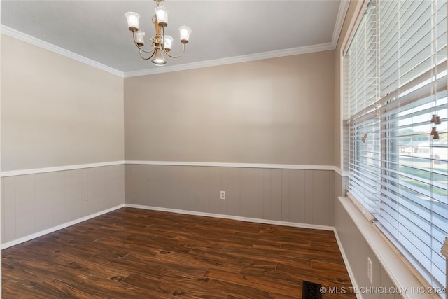 spare room featuring a wainscoted wall, ornamental molding, wood finished floors, and an inviting chandelier