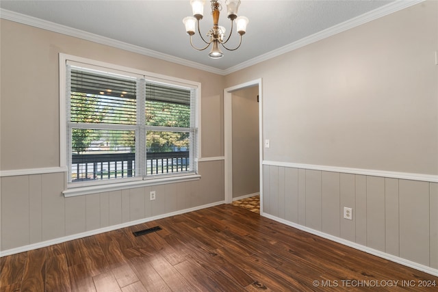 spare room with wainscoting, a notable chandelier, visible vents, and wood finished floors