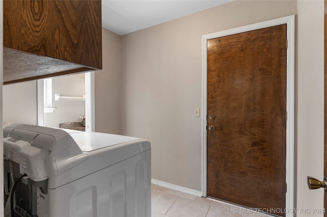 laundry area featuring cabinet space, baseboards, separate washer and dryer, and light tile patterned flooring