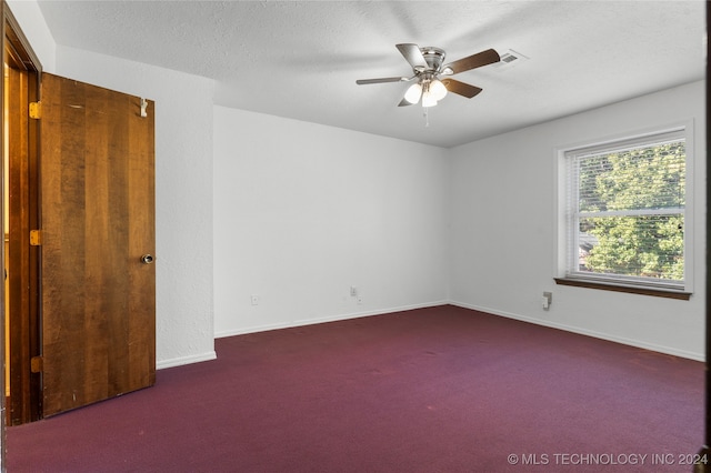 unfurnished room featuring carpet, visible vents, a ceiling fan, a textured ceiling, and baseboards