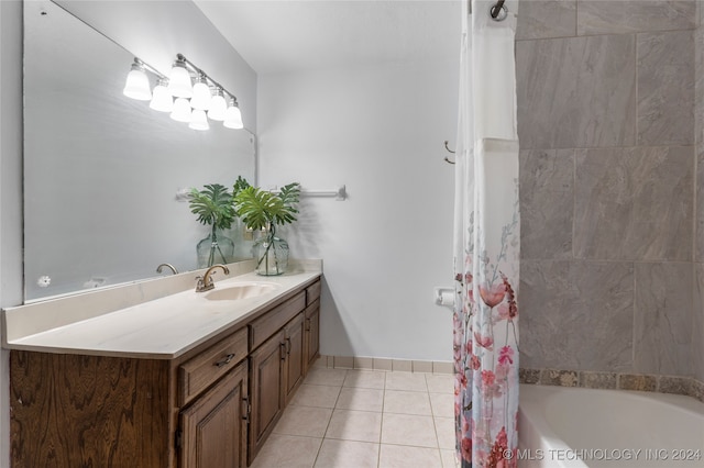 bathroom featuring shower / bath combo with shower curtain, vanity, baseboards, and tile patterned floors