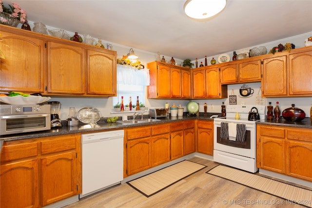 kitchen with white appliances, light hardwood / wood-style floors, ornamental molding, and sink