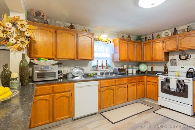 kitchen with sink, light hardwood / wood-style floors, and white appliances