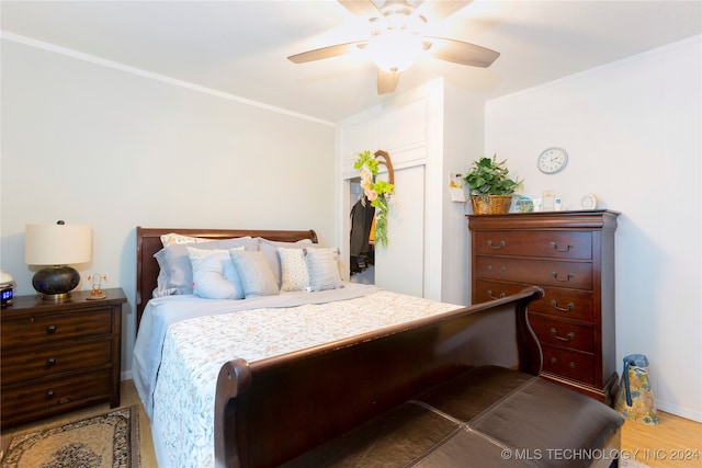 bedroom with ornamental molding, hardwood / wood-style flooring, and ceiling fan