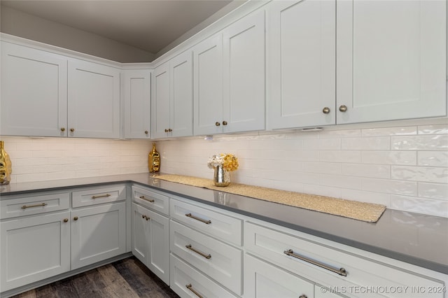 kitchen featuring backsplash, dark hardwood / wood-style flooring, and white cabinets