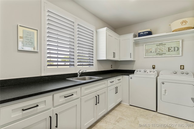 laundry area featuring sink, washer and dryer, and cabinets