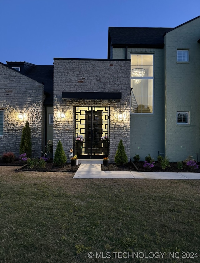 entrance to property featuring french doors and a lawn