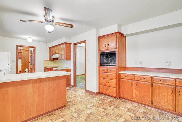 kitchen with kitchen peninsula, white fridge, and ceiling fan