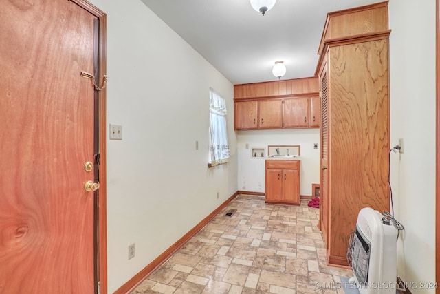 laundry room featuring hookup for a washing machine, heating unit, and cabinets