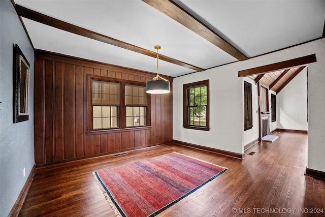 spare room with dark hardwood / wood-style flooring, beamed ceiling, and wood walls