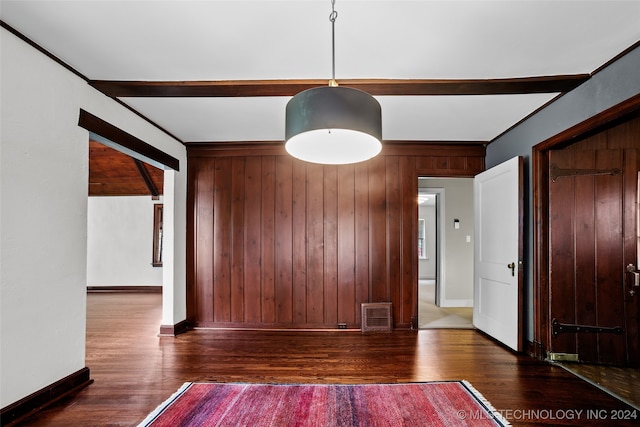 unfurnished room with dark wood-type flooring and wooden walls