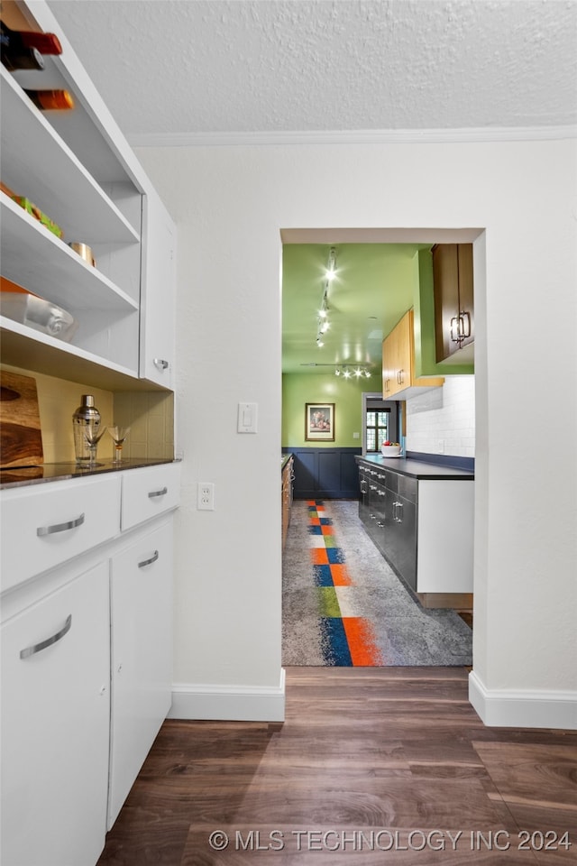 kitchen with white cabinets, a textured ceiling, and dark hardwood / wood-style flooring