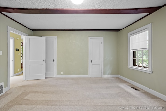 carpeted spare room featuring a textured ceiling