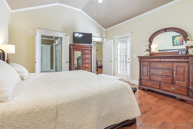 bedroom featuring lofted ceiling, crown molding, and hardwood / wood-style flooring