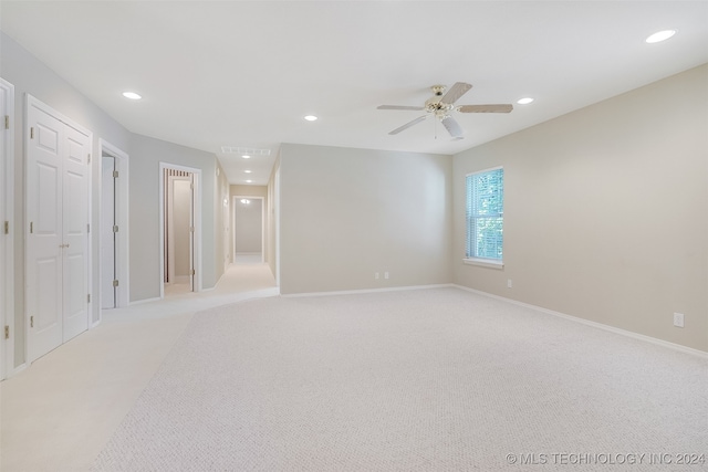 carpeted spare room featuring ceiling fan