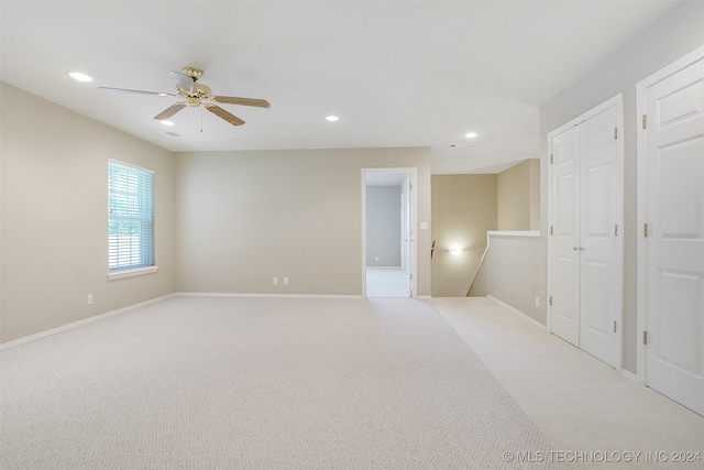 carpeted spare room with ceiling fan