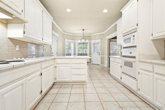 kitchen featuring crown molding, white cabinets, pendant lighting, and white appliances