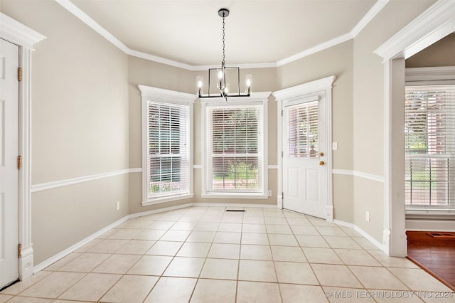 unfurnished dining area featuring a wealth of natural light, ornamental molding, a chandelier, and light tile patterned floors