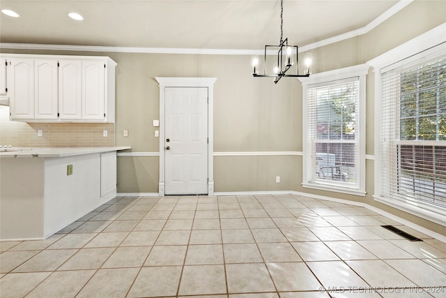 kitchen featuring decorative backsplash, crown molding, light tile patterned flooring, pendant lighting, and white cabinetry