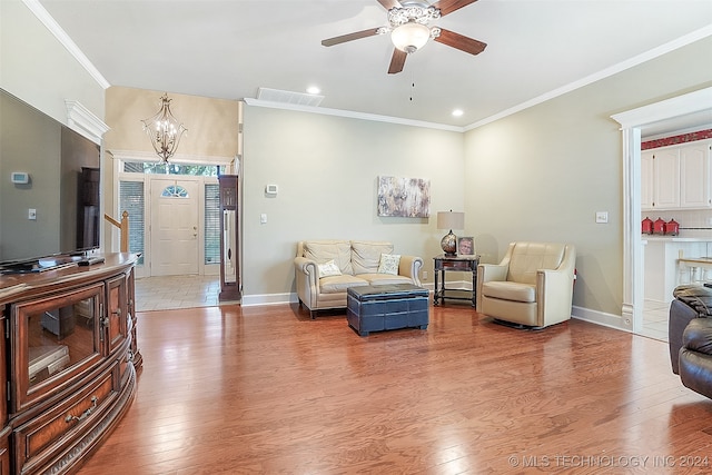 living room featuring light hardwood / wood-style floors, crown molding, and ceiling fan with notable chandelier