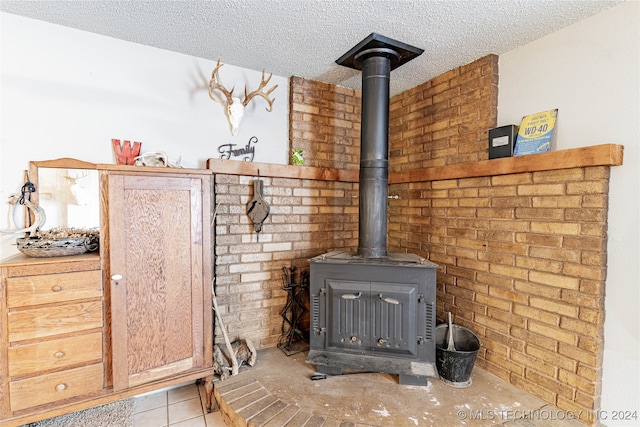 interior details featuring a textured ceiling, a wood stove, and tile patterned flooring